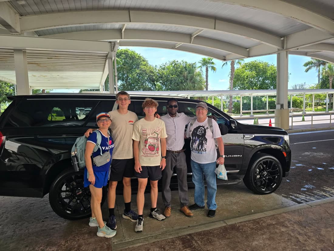 Mike with a family beside the Yukon at Nassau airport
