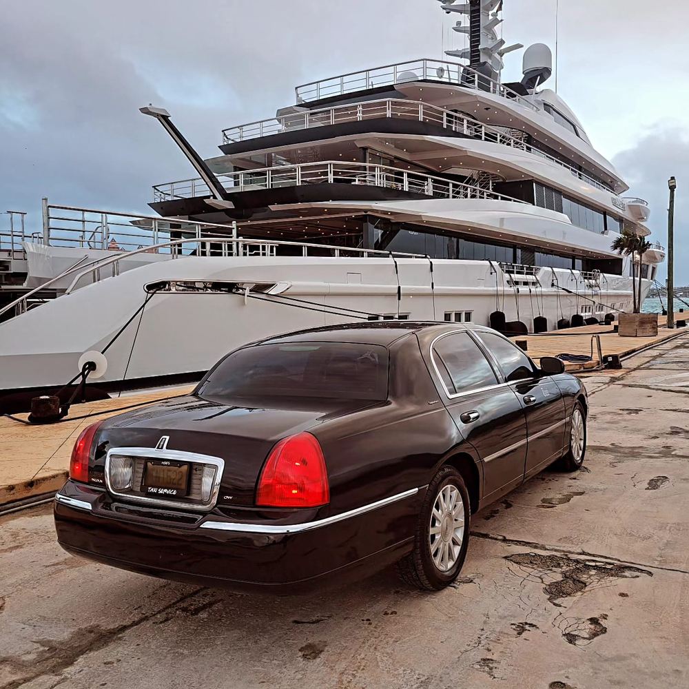 The Lincoln Town Car on the dock beside a superyacht